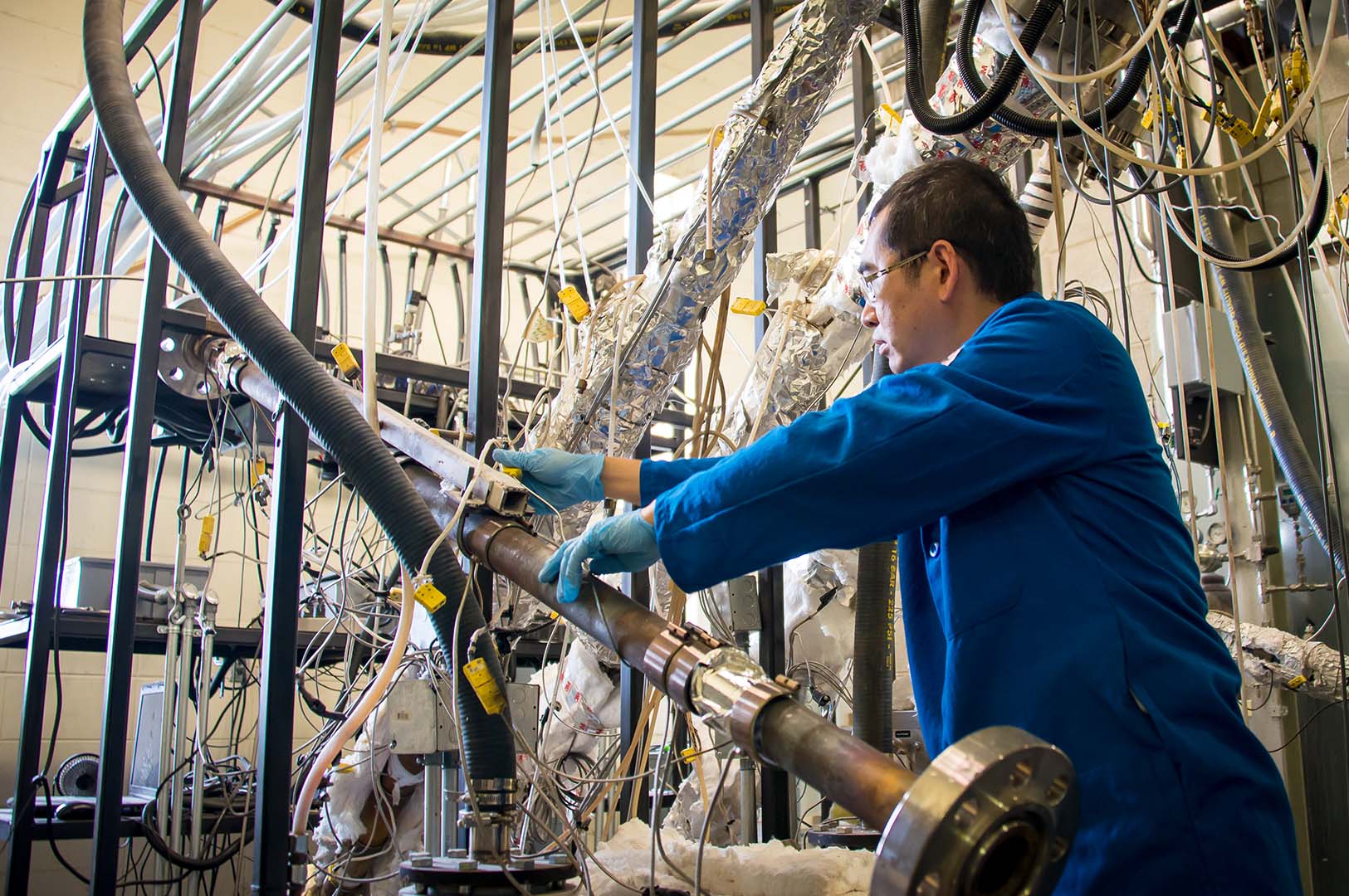 Dr. Fei Yu working on the bioenergy pilot plant on the Mississippi State University campus. (Photo by David Ammon)