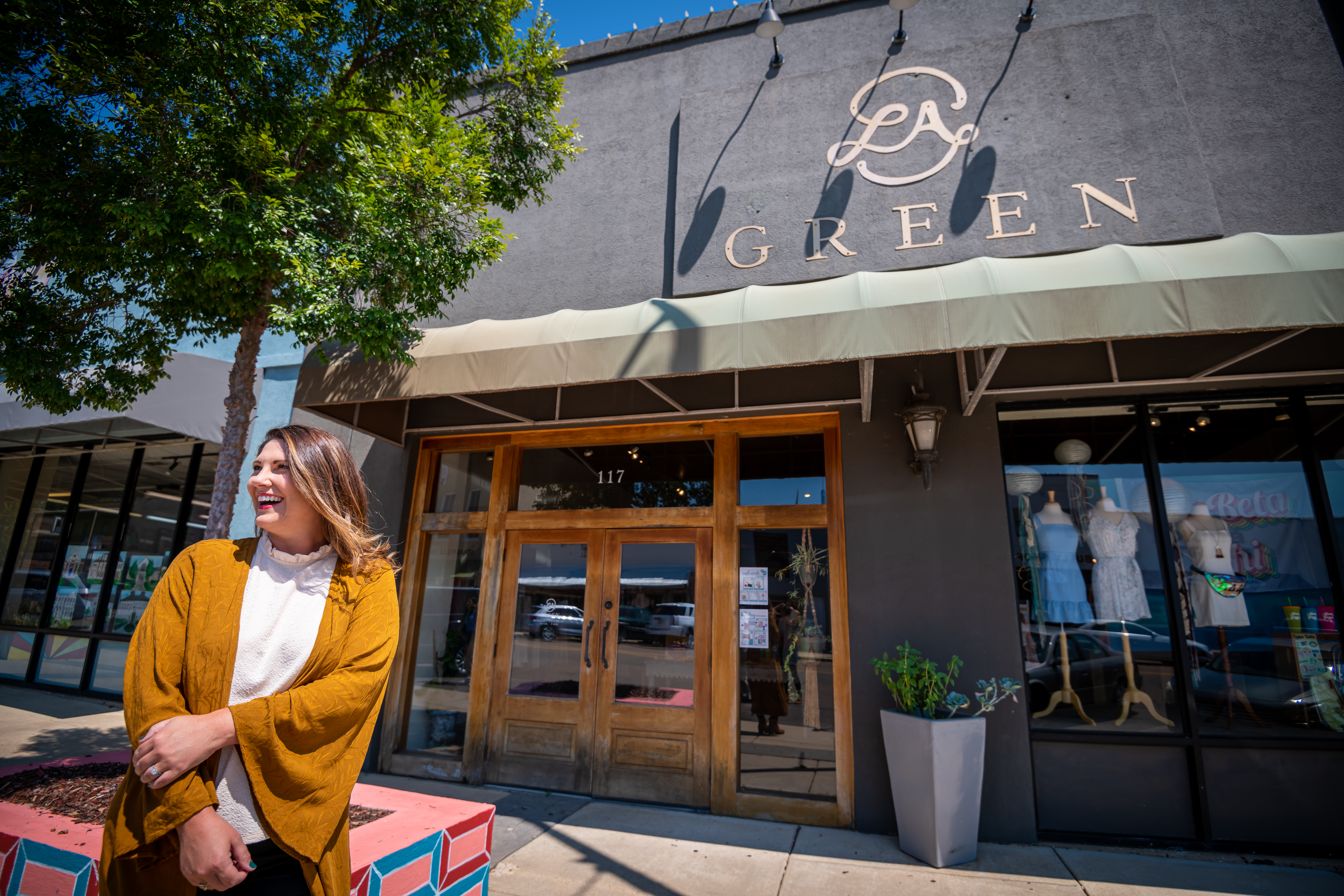 Lauren Ann Cooper, a MSU College of Agriculture and Life Sciences alumna, poses outside her store, LA Green. (Photo by David Ammon)